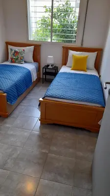 a bedroom with two beds and a window at Tamesna HOUSE in Sidi Yahia az Zaʼer