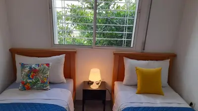 two beds in a room with a window at Tamesna HOUSE in Sidi Yahia az Zaʼer