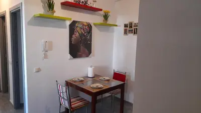 a dining room table with two chairs and a painting on the wall at Tamesna HOUSE in Sidi Yahia az Zaʼer
