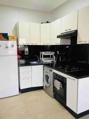 a kitchen with a stove and a washing machine at Appartement pieds dans l’eau Tamaris in Casablanca