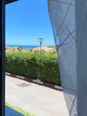 a view from a window of a street with a bush at Appartement pieds dans l’eau Tamaris in Casablanca