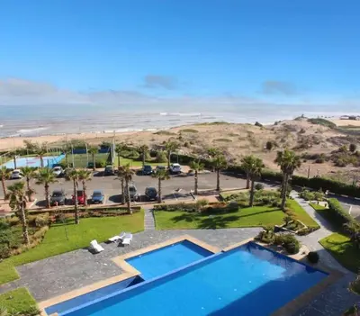 an aerial view of a resort with a swimming pool and the beach at Appartement pieds dans l’eau Tamaris in Casablanca