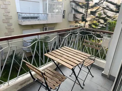 a balcony with two chairs and a wooden bench at OASIS BEACH APPARTEMENT MEUBLé RESIDENCE FERMÉE AVEC PISCINE TAMARIS 2 SIDI RAHAL in Sidi Rahal