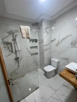 a bathroom with a shower and a toilet and a sink at OASIS BEACH APPARTEMENT MEUBLé RESIDENCE FERMÉE AVEC PISCINE TAMARIS 2 SIDI RAHAL in Sidi Rahal