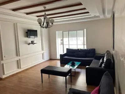 a living room with a couch and a table at OASIS BEACH APPARTEMENT MEUBLé RESIDENCE FERMÉE AVEC PISCINE TAMARIS 2 SIDI RAHAL in Sidi Rahal