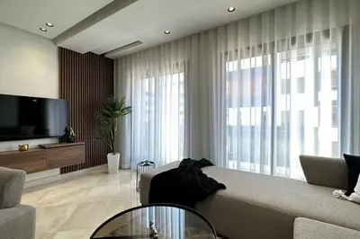 a living room with a couch and a tv at Luxurious 2 Suites Apt - By AppartAli in Casablanca