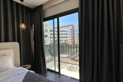 a bedroom with a bed and a window with a balcony at Luxurious 2 Suites Apt - By AppartAli in Casablanca