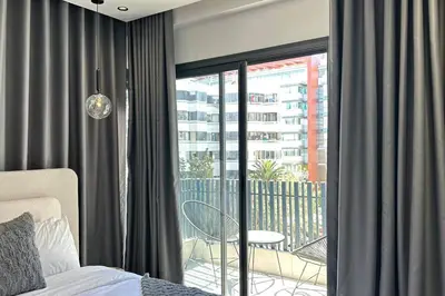a bedroom with a bed and a balcony with a view at Luxurious 2 Suites Apt - By AppartAli in Casablanca