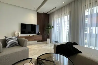 a living room with a couch and a tv at Sunny 2 Bedrooms - By AppartAli in Casablanca