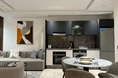 a living room with a couch and a table in a kitchen at Sunny 2 Bedrooms - By AppartAli in Casablanca