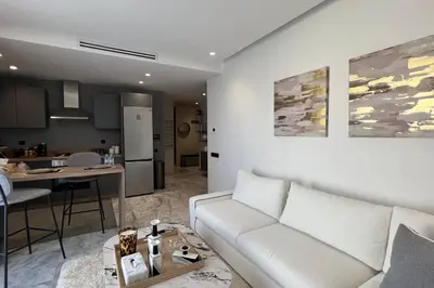 a living room with a white couch and a kitchen at Casablanca Downtown 21 - By AppartAli in Casablanca