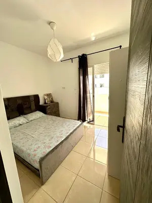 a bedroom with a bed and a sliding glass door at chez mehdi in Skhirat