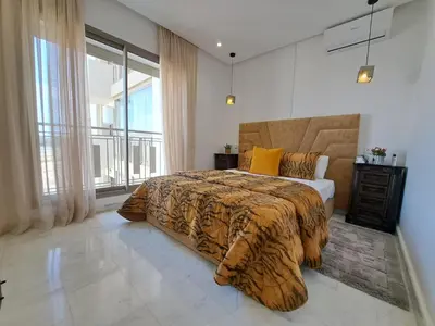 a bedroom with a bed with a tiger print blanket at Studio Casablanca aéroport nouaceur in Nouaceur