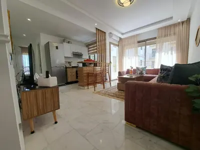 a living room with a couch and a kitchen at Studio Casablanca aéroport nouaceur in Nouaceur