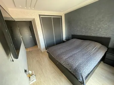 a bedroom with a bed with a blue comforter at APPARTEMENT HAUT STANDING proche gare casa voyageur in Casablanca