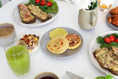 a white table with plates of food and a glass of juice at Stayhere Casablanca - Maarif - Elite Residence in Casablanca