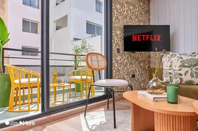 a room with a table and chairs on a balcony at Stayhere Casablanca - Maarif - Elite Residence in Casablanca