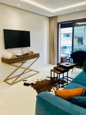 a living room with a tv and a blue couch at Atlantic Suite View 3 in Casablanca