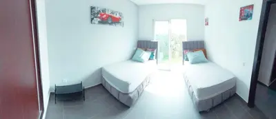 a room with two beds and a chair in it at Appartement luxueux et moderne à sidi Rehal in Dar Hamida