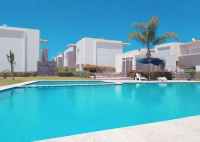 a swimming pool in front of some buildings at Appartement luxueux et moderne à sidi Rehal in Dar Hamida