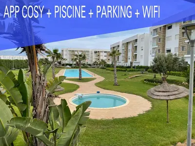 a resort with a swimming pool and a building at Superbe Appt avec grande piscine 2 in Dar Bouazza