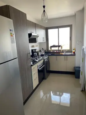 a kitchen with a refrigerator and a stove top oven at Superbe Appt avec grande piscine 2 in Dar Bouazza