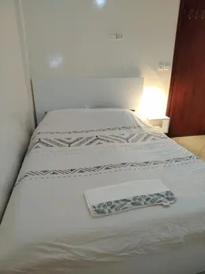 a white bed with a towel on top of it at Appartement Casa Voyageurs in Casablanca