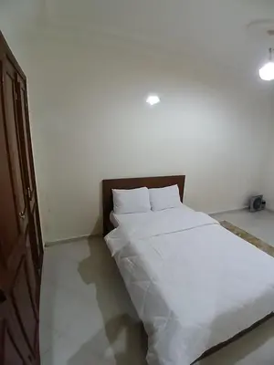 a bed with white sheets and pillows in a room at Appartement Casa Voyageurs in Casablanca