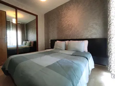 a bedroom with a large bed with a large mirror at rabatapartmentresidence in Rabat