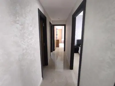 a hallway with black doors and white walls at rabatapartmentresidence in Rabat
