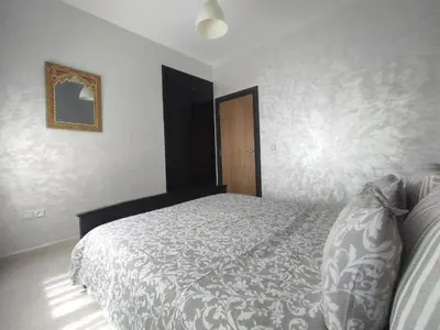 a bedroom with a bed and a picture on the wall at rabatapartmentresidence in Rabat