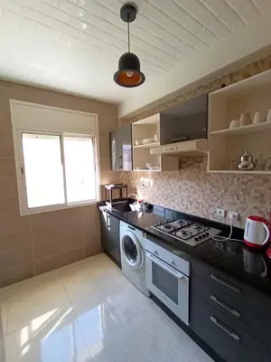 a kitchen with a stove and a washing machine at rabatapartmentresidence in Rabat