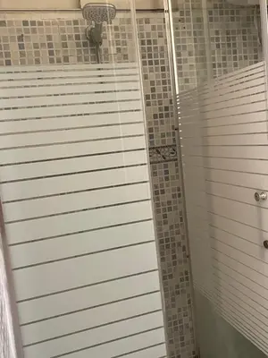 a shower with gray tiles in a bathroom at Private room in Casablanca