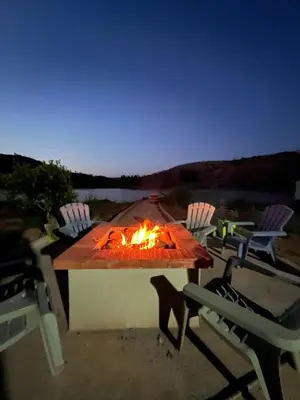 a fire pit on a patio with chairs around it at Lake House Boulaouane in El Jadida