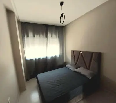 a bedroom with a bed in front of a window at Appartement cosy proche Aéroport in Deroua
