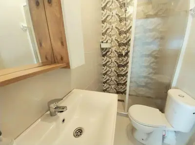 a white bathroom with a toilet and a sink at Appartement cosy proche Aéroport in Deroua