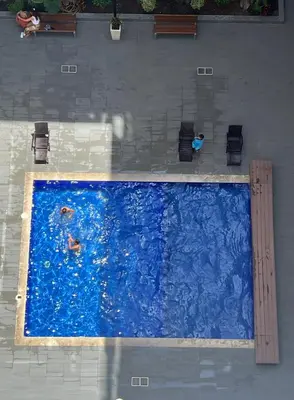 a large swimming pool with people in the water at Magnifique duplex moderne à 1 minute à pied de la plage- Résidence Miramar Mohammedia in Mohammedia