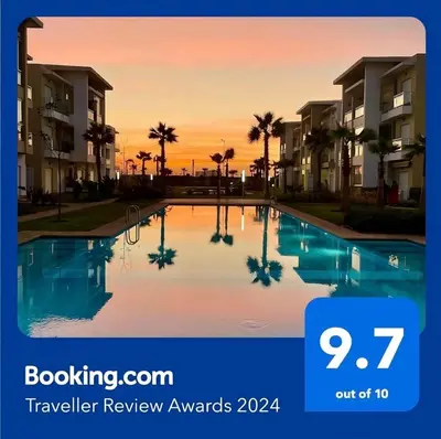 a villa with a swimming pool at sunset at Cosy Apartment with sea view in Sidi Rahal
