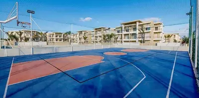 a basketball court in front of a apartment complex at Cosy Apartment with sea view in Sidi Rahal