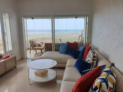 a living room with a couch and a view of the beach at Appartement Front de mer avec vue Panoramique in Casablanca