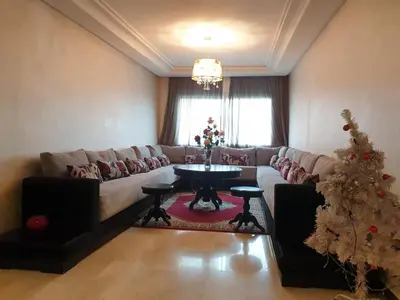 a living room with a couch and a christmas tree at Mosquée & Foire by Saloua in Casablanca