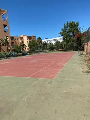 a tennis court in front of a building at Appartement mohamedia Ricoflores vue sur piscine in Mohammedia