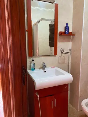 a bathroom with a white sink and a mirror at Appartement mohamedia Ricoflores vue sur piscine in Mohammedia