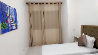 a bedroom with a bed and a glass shower at Appartement Costa Bouznika in Bouznika