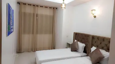 a bedroom with two beds and a window at Appartement Costa Bouznika in Bouznika