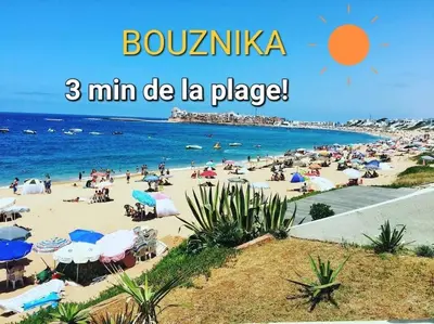 a beach with a large group of people on it at Appartement Costa Bouznika in Bouznika