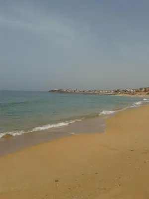 a sandy beach with the ocean in the background at Bahia beach . Plage dahomey in Bouznika