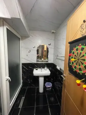 a bathroom with a sink and a dartboard on the wall at Bahia beach . Plage dahomey in Bouznika