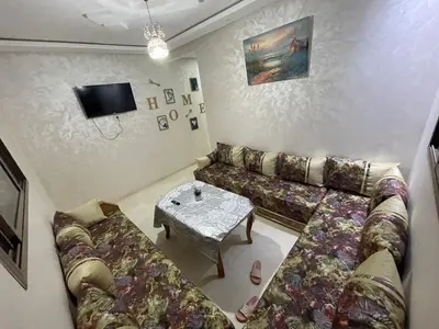 a living room with a couch and a table at Bahia beach . Plage dahomey in Bouznika