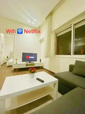 a living room with a couch and a tv at Joli Studio au Centre Ville avec WIFI - Netflix in Casablanca